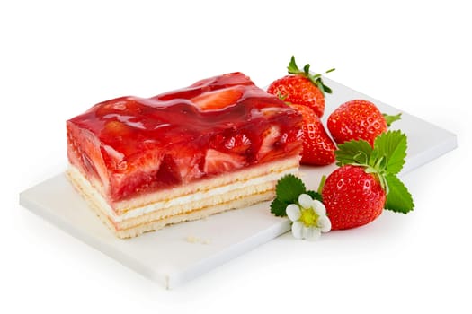 Delicious freshly baked layer cake topped with strawberries served on a white board with fresh whole fruit isolated on white