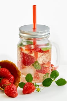 Masons Jar of iced strawberry and mint infused water with a cornet ice cream cone spilling ripe red fruit alongside