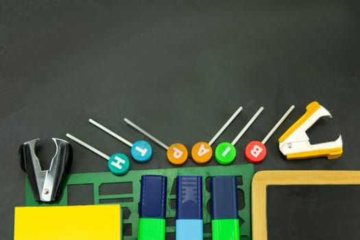 Closeup of colorful school supplies with copy space on blackboard background. Back to school.