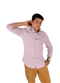 A handsome middle age man standing in a red checkered shirt with his .hand behind his head, looking at camera, isolated for white background.