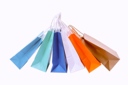 Variety of colored paper shopping bags on white background. Empty area.