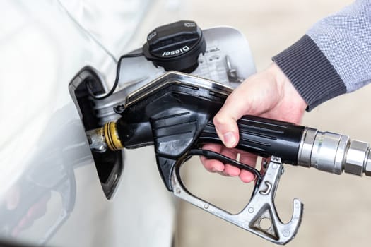 Pumping gas at gas pump. Closeup of man pumping gasoline fuel in car at gas station.