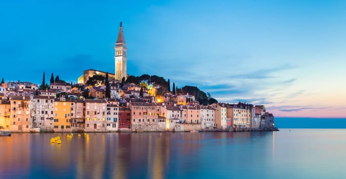 Colorful sunset of Rovinj town, Croatian fishing port on the west coast of the Istrian peninsula. Colorful evening seascape of Adriatic Sea. Traveling concept.