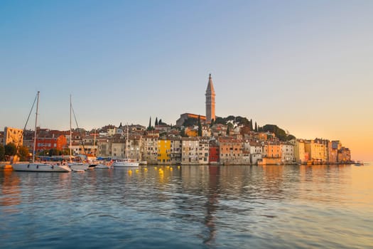 Colorful sunset of Rovinj town, Croatian fishing port on the west coast of the Istrian peninsula. Colorful evening seascape of Adriatic Sea. Traveling concept.