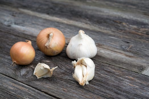 garlic and onion on gray - brown wooden ground