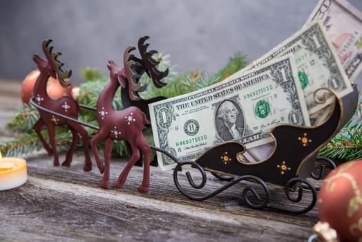 christmas sill with money in reindeer carriage , fir branch and candle