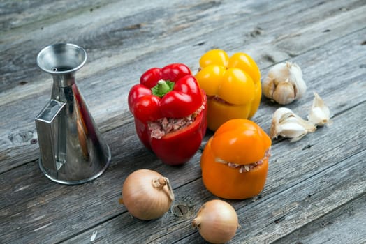 colorful filled pepper,oil,garlic and onion on wooden ground