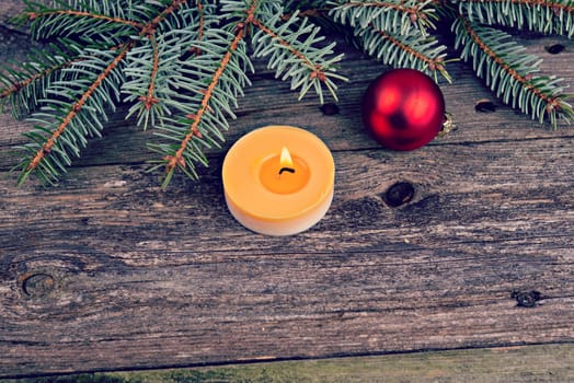 christmas sill with fir branch and candle on wooden ground