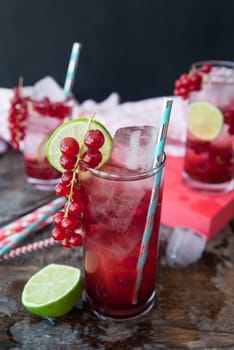 High glass with cocktail with fresh red currants and lime