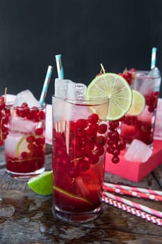 High glass with cocktail with fresh red currants and lime