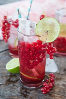 High glass with cocktail with fresh red currants and lime