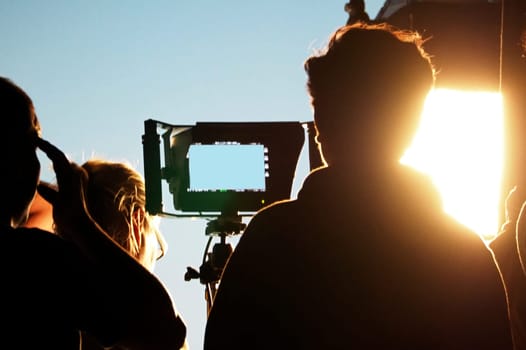 Blurry images of silhouette people film crew team working behind the scenes for shooting video production with professional equipment camera and lighting in the studio.