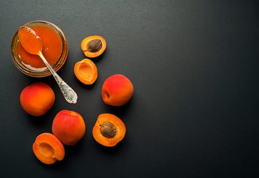 Apricot jam in a glass bowl with fruit around