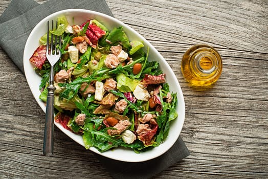 Tuna salad with lettuce beans and cheese on wooden table
