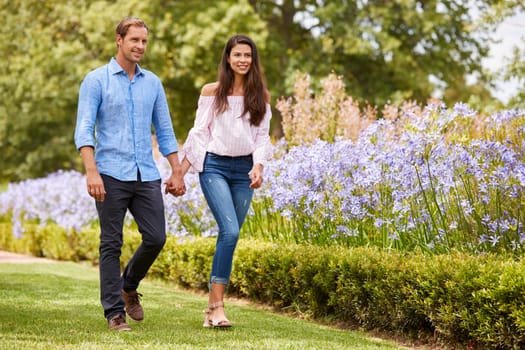 Couple Holding Hands On Romantic Walk In Park Together