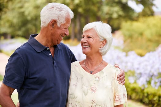 Senior Couple Enjoying Walk In Park Together