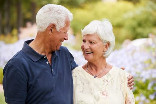 Senior Couple Enjoying Walk In Park Together