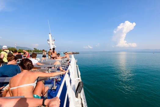 SURAT THANI, THAILAND-APRIL 28, Group of tourists are resting on the deck during the travel by boat on the sea in summer arrive at the pier of Ko Pha Ngan island, APRIL 28, 2017 in Thailand