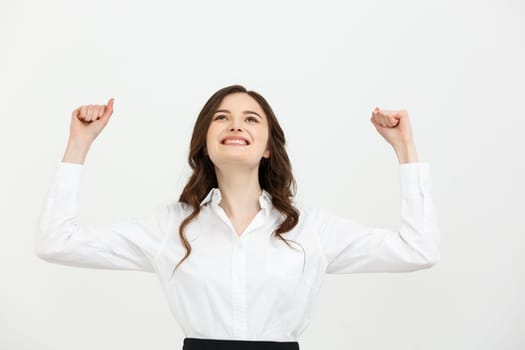 Business Concept: young happy businesswoman with hands in the air is celebrating success on white background.