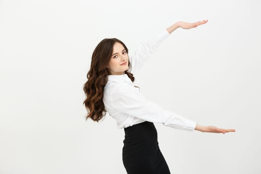 Advertisement concept. Portrait of gorgeous caucasian businesswoman showing two hands on copy space on grey background, presenting new product.