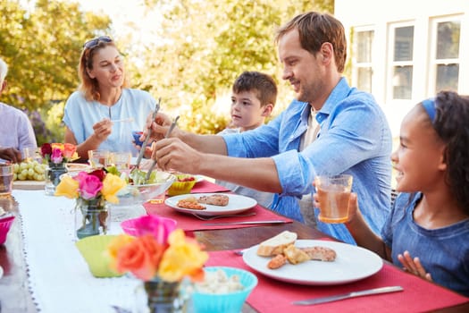 Friends and family having lunch at a table in the garden