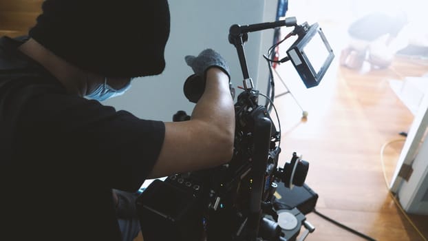 Video camera ultra high definition on pan and tilt head professional tripod with rig and gimbal operated by film crew team that recording or shooting tvc movie at location with monitor.