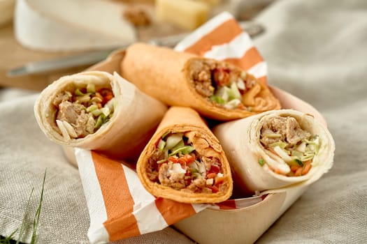 Tasty doner kebabs or wraps outdoors at a summer picnic in a close up view on the filling suitable for advertising or a menu