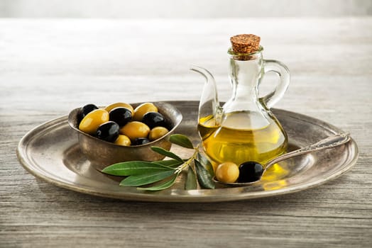 Olive oil and olive branch on wooden table
