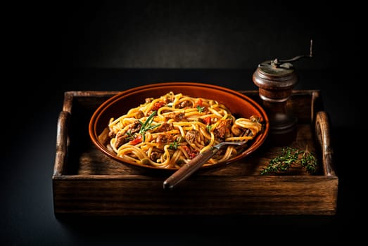 Delicious spaghetti with bolognese sauce served on black background