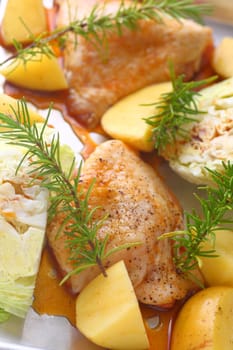 Vertical view of marinated chicken thighs, cabbage wedges and potatoes ready to go in the oven