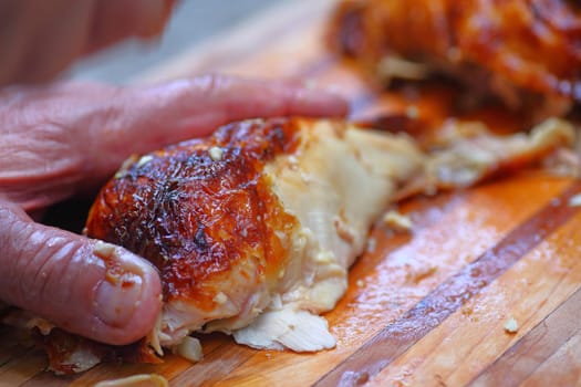 A man prepping a roast chicken breast on a cutting board