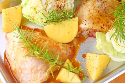 Small sheet pan dinner with marinated chicken thighs, Yukon gold potatoes, savoy cabbage and rosemary