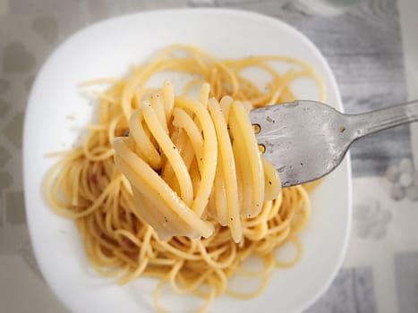 Top view of a fork swirling cooked spaghetti