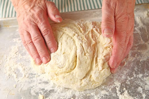 Male cook kneads dough for baking powder biscuits
