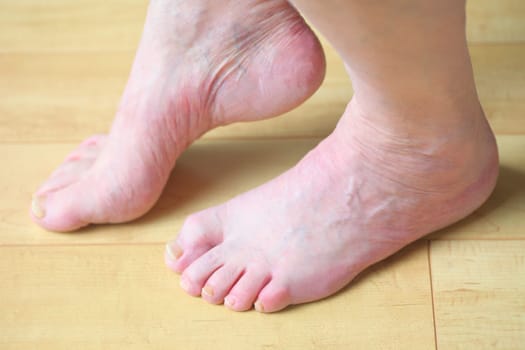 A man slightly raises one bare foot on the floor