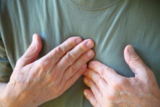 Senior man feels cardiac pain closeup