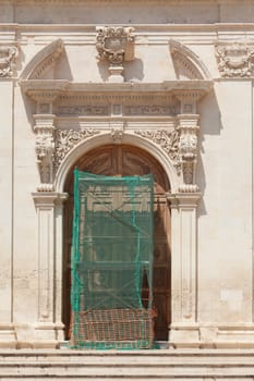 Old church door,scaffolding,construction site,restoration,old town,Noto,UNESO World Heritage Site,Vale di Noto,province of Syracuse,Sicily,Italy,Europe