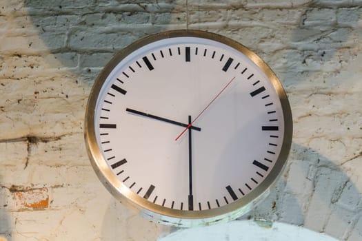 Big old clock in an old factory in front of a window
