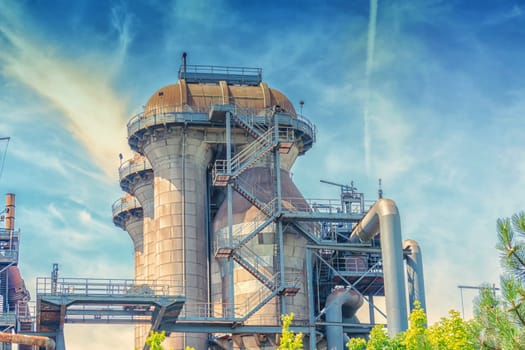 General view of an industrial plant refinery, consisting of pipes and towers of heavy industry.