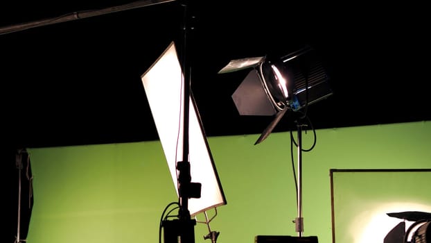 Big studio lighting kit 5000 watt with soft box on tripod and professional green screen background chroma key post production technique shooting or filming for movie or video commercial set up.
