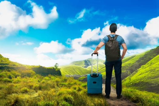 Young asian tourist man with backpack enjoying view at nature with blue sky background