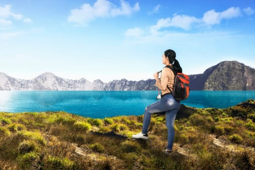 Young asian traveler woman with backpack looking at lake view on the mountain