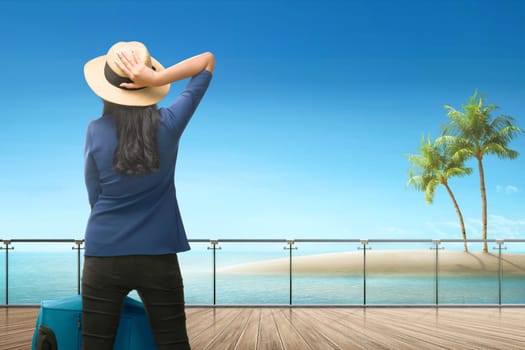 Back view of asian female traveler looking at ocean view from terrace