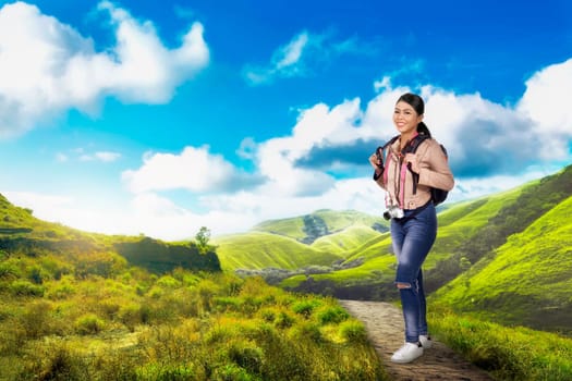 Happy asian backpacker woman traveling on the green valley