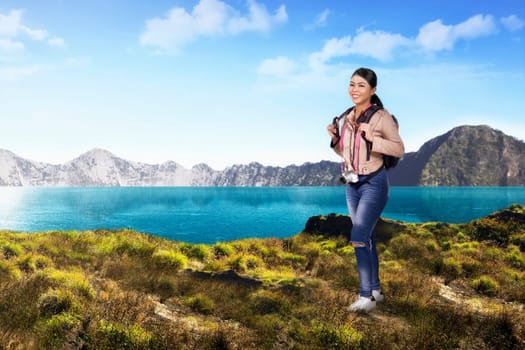 Smiling asian traveler woman enjoying view on the mountain