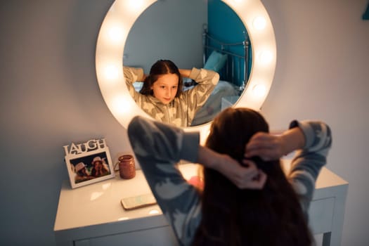 Little girl is brushing her hair at the mirror in her bedroom.