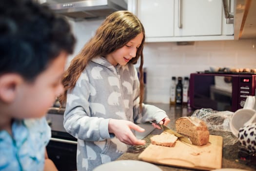 Little girl is taking a slice of bread to make toast for breakfast.
