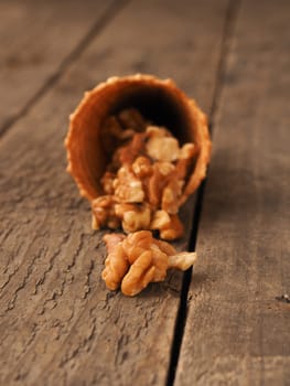 Ice cream cone with organic walnuts on a rustic wooden table