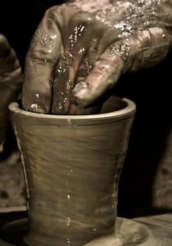 Detail of a potter's hand while creating a new work of art