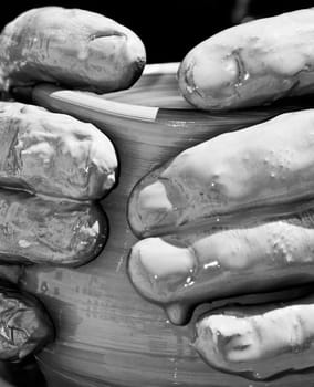 Detail shot of a potter's fingers while busy